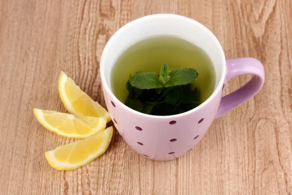 Nane çayı, nane yaprağı ve limon ahşap zemin üzerinde — Stok fotoğraf