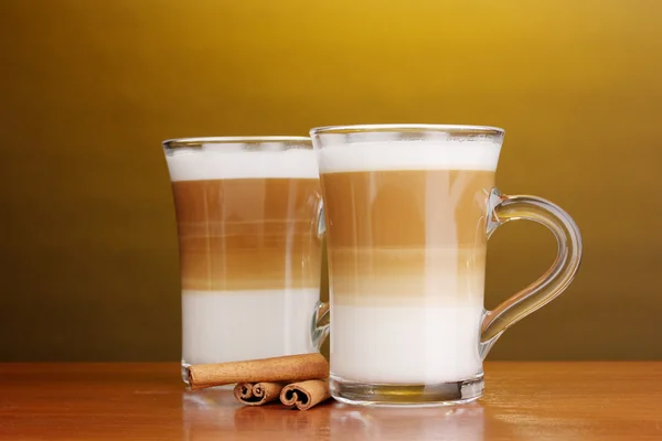 Güzel kokulu? offee latte cam bardak ve tarçın kahverengi zemin üzerine ahşap tablo — Stok fotoğraf
