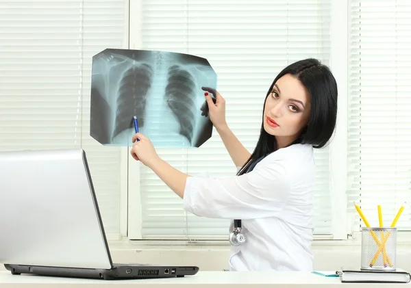 Schöne Ärztin hält Röntgen im Büro — Stockfoto