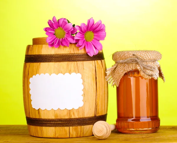 Mel doce em jarra e barril com drizzler na mesa de madeira no fundo verde — Fotografia de Stock