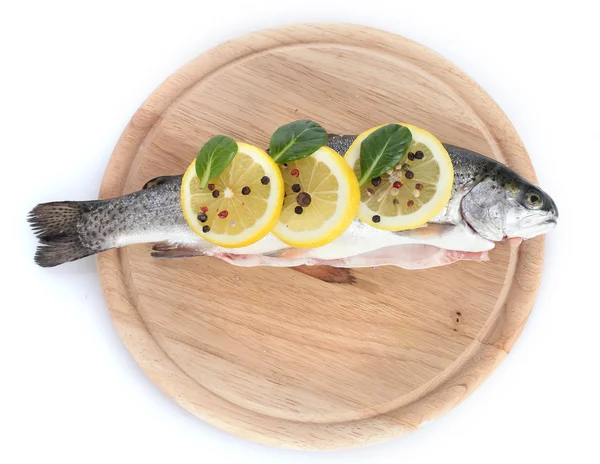 Peixe fresco com limão, salsa e pimenta em tábua de corte de madeira isolada em branco — Fotografia de Stock