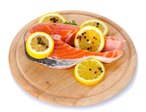 Красная рыба с лимоном и специями на деревянной доске, изолированной на белом — стоковое фото