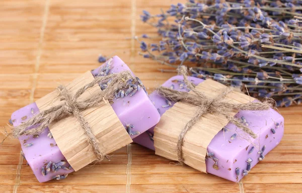 Handgjorda lavendel tvålar på trä matta — Stockfoto