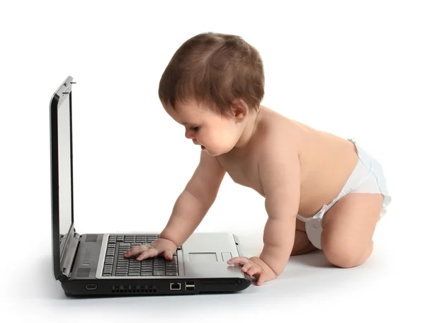 Schattige babymeisje en laptop geïsoleerd op wit — Stockfoto