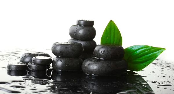 Piedras de spa con gotas y hojas verdes sobre fondo blanco —  Fotos de Stock