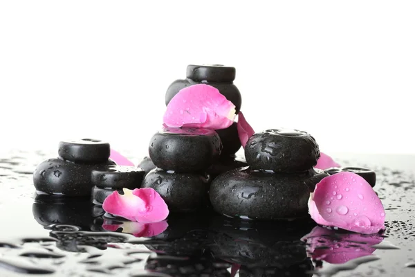 Piedras de spa con gotas y pétalos de rosa sobre fondo blanco — Foto de Stock