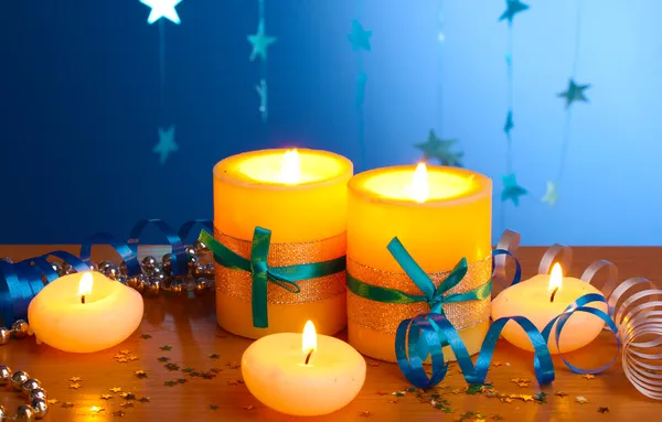 Beautiful candles, gifts and decor on wooden table on blue background Stock Picture