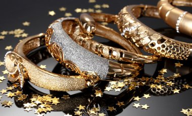 Beautiful golden bracelets on grey background clipart