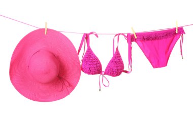 Women's swimsuit and hat hanging on a rope on white background clipart