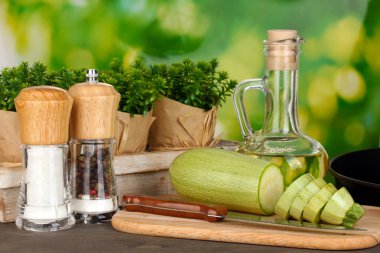 Kesme tahtasında dilimlenmiş kabak. Ahşap masada yeşil arka planda.