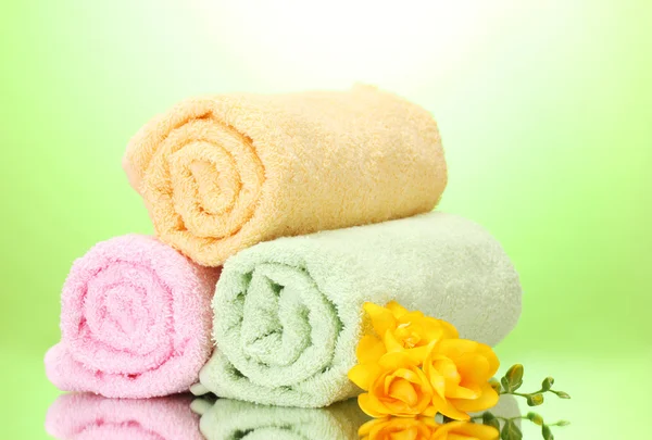 Kolorowe ręczniki i kwiaty na zielonym tle żółty — Zdjęcie stockowe