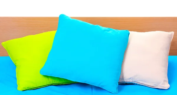 Яскраві подушки на ліжку на білому тлі — стокове фото