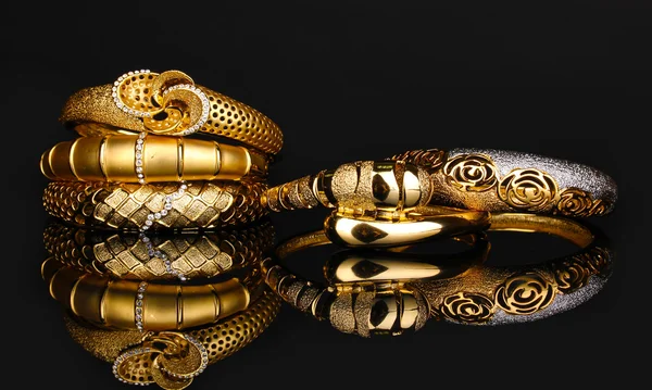 Beaux bracelets dorés isolés sur fond noir — Photo