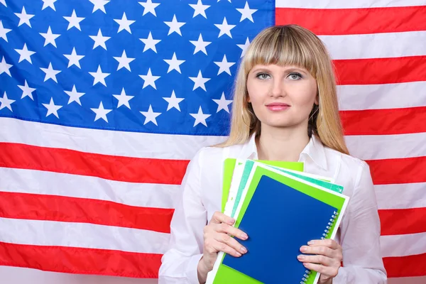 Молодая женщина на фоне флага Америки — стоковое фото