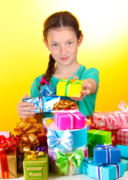 礼品在黄色背景上的小女孩 — 图库照片