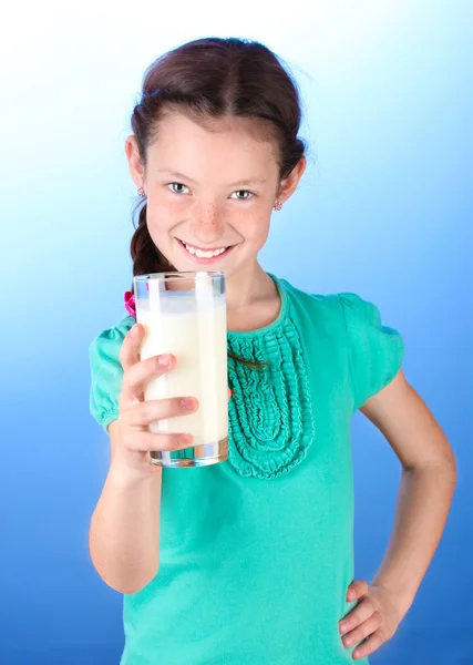 Portret piękny mały dziewczyna withglass mleka na niebieskim tle — Zdjęcie stockowe