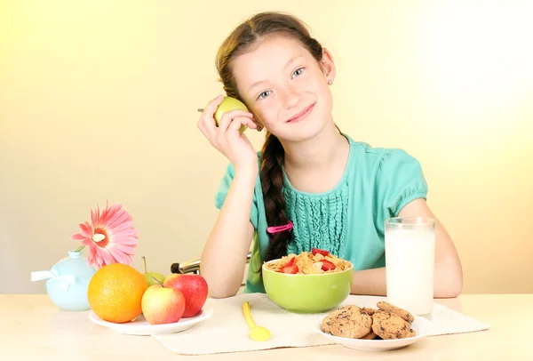 Mooi meisje een ontbijten op beige achtergrond — Stockfoto