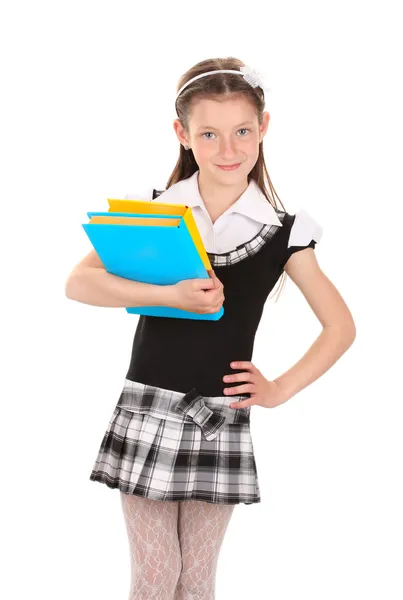 Linda menina em uniforme escolar com livros isolados em branco — Fotografia de Stock