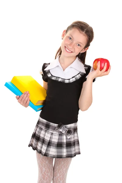 Vacker liten flicka i skoluniform med böcker och apple isolerad på vit — Stockfoto