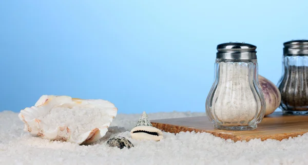 Mořská sůl na pláži a na prkénku na modrém pozadí — Stock fotografie