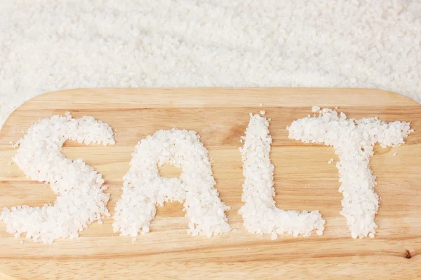 Mořská sůl na řezací deska detail — Stock fotografie
