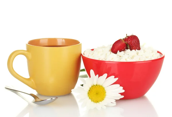 Cottage cheese with strawberry in red bowl and orange cup with coffee, spoon and flower isolated on white — Stock Photo, Image