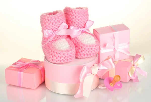 Pembe bebek botları, emzik ve üzerinde beyaz izole hediyeler — Stok fotoğraf