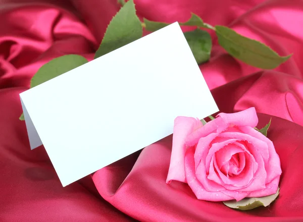 Mooie roos op donker roze doek — Stockfoto