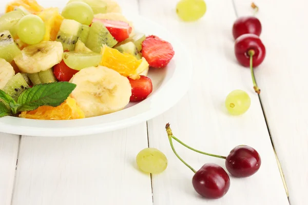 新鲜水果沙拉上板和白色的木桌上的浆果 — 图库照片