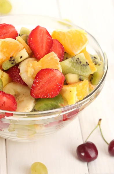 Tazón de cristal con ensalada de frutas frescas y bayas en mesa de madera blanca —  Fotos de Stock