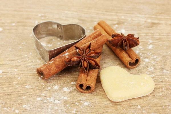 Cutter for biscuits with cinnamon and anise on wooden table close-up — Stock Photo, Image