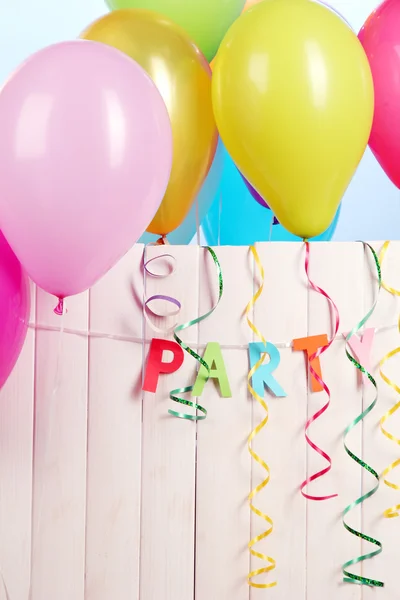 Party. Luftballons gegen einen Holzzaun auf blauem Hintergrund — Stockfoto