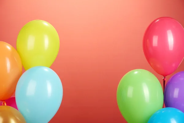Kolorowe balony na czerwonym tle — Zdjęcie stockowe