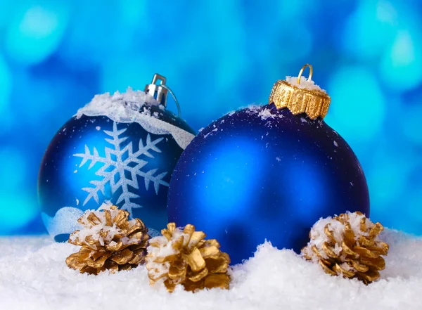 Όμορφη μπλε μπάλες Χριστούγεννα και κώνους στο χιόνι σε μπλε φόντο — Φωτογραφία Αρχείου