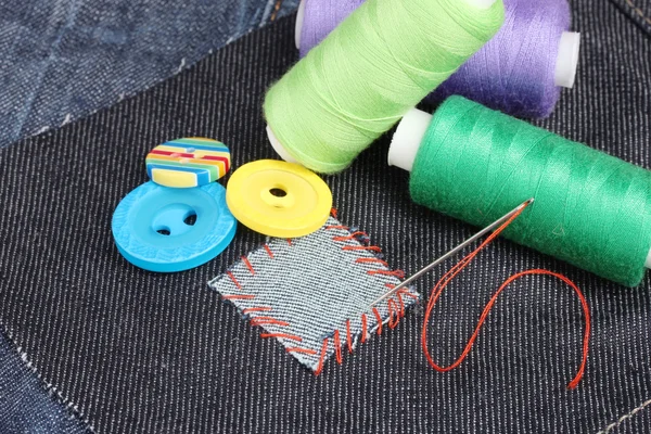 Rhomb-vormige patch op jeans met draden en knoppen close-up — Stockfoto