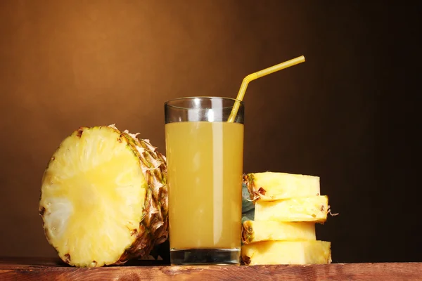 Succo di ananas e ananas su marrone — Foto Stock