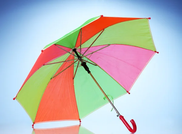 Multi-colored umbrella on blue background — Stock Photo, Image