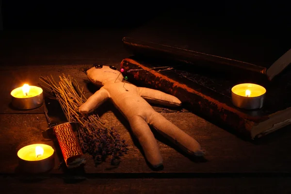 木製のテーブル、ろうそくの光でブードゥー教の人形の少年 — ストック写真