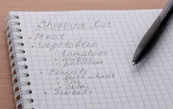 购物清单和木桌上的钢笔 — 图库照片