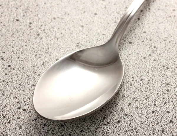 Spoon on marble table — Stock Photo, Image