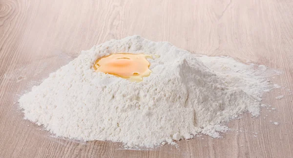 Egg in flour on wooden table — Stock Photo, Image