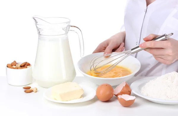 Mains féminines Mélanger les œufs dans un bol isolé sur blanc — Photo