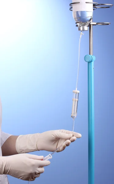 Nurse doing infusion on blue background — Stock Photo, Image