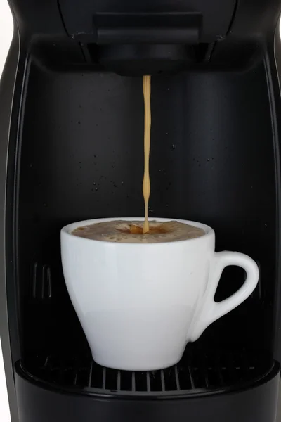 Эспрессо-машина наливает кофе в белую чашку — стоковое фото