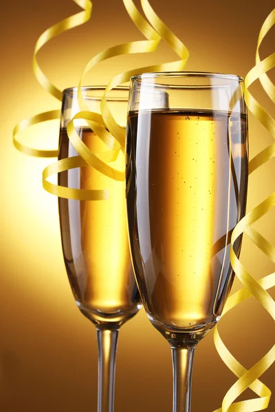 Окуляри шампанського та стример на жовтому фоні — стокове фото