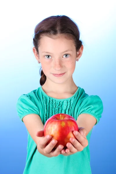 Portret van mooi meisje met apple op blauwe achtergrond — Stockfoto