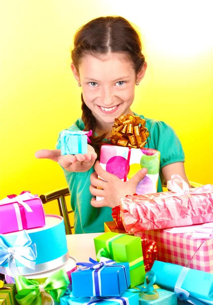 Petite fille avec des cadeaux sur fond jaune — Photo