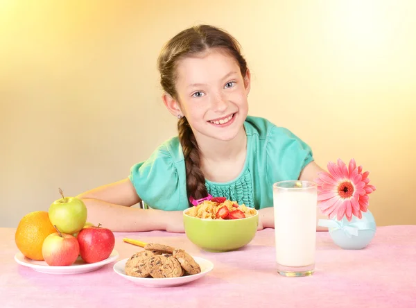 美丽的小女孩吃早餐米色背景上 — 图库照片