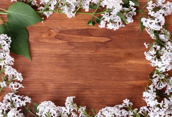 La cornice dei rami di un lilla su sfondo di legno — Foto Stock