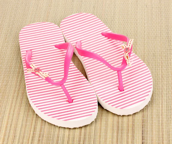 Pink beach slippers on mat — Stock Photo, Image